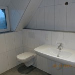 Waschbecken und Toilette unter Dachschräge
