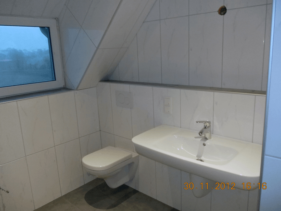 Waschbecken und Toilette unter Dachschräge